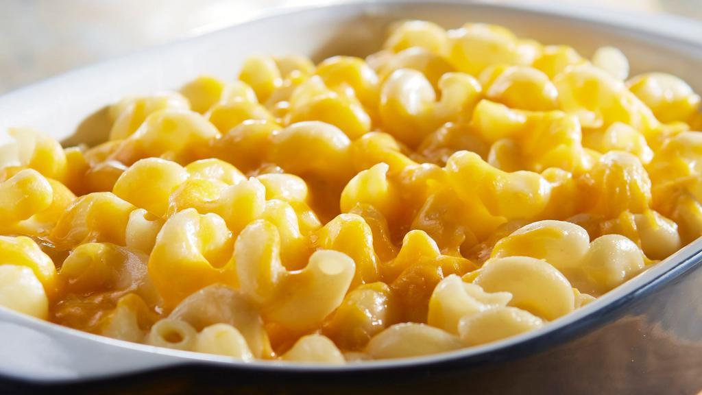 Macaroni And Cheese · Tender corkscrew pasta tossed in creamy white cheddar cheese sauce, topped with cheddar cheese. Serves 2-4.