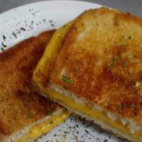 Grilled Cheese Sandwich · Yellow american cheese grilled in between two white pieces of bread.