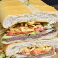 Pan Con Bistec · Palomilla steak cooked with onions, ham, potatoes sticks, lettuce and tomatoes.