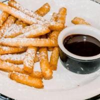 Funnel Cake Fries Del · Funnel cake fries topped with powdered sugar with chocolate sauce for dipping.