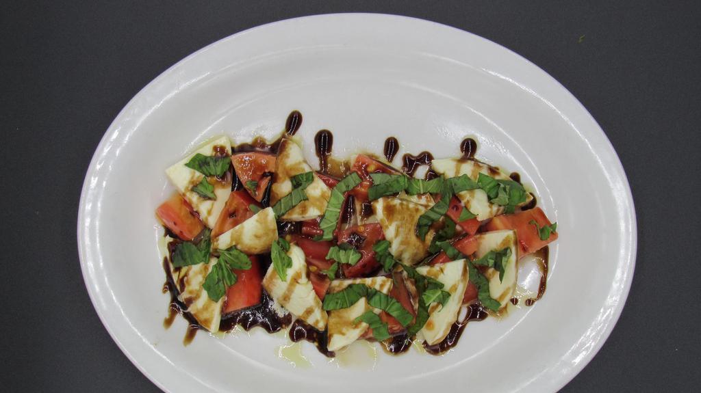 Caprese Salad · Fresh mozzarella and tomatoes tossed in EVOO, fresh basil and drizzled with balsamic glaze.