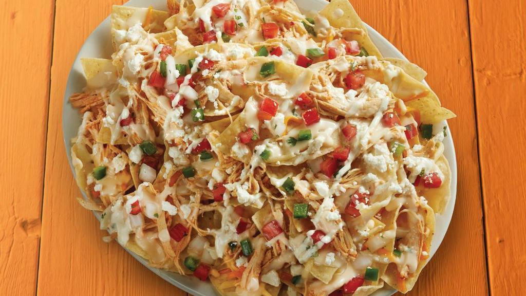 Shredded Chicken Nachos · Fresh tortilla chips topped with shredded chicken, shredded cheese, queso, feta, pico de gallo, and garlic sauce.. {GF} = Gluten Friendly *please note that chips are fried in a fryer that may allow cross-contact in some locations. {DF - remove queso, shredded, and feta cheese}