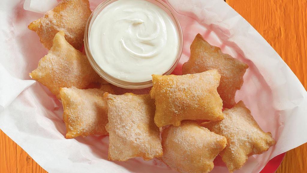 Sopapilla Bites · Freshly cooked bite-size sopapillas sprinkled with cinnamon-sugar and served with sweet vanilla cream.