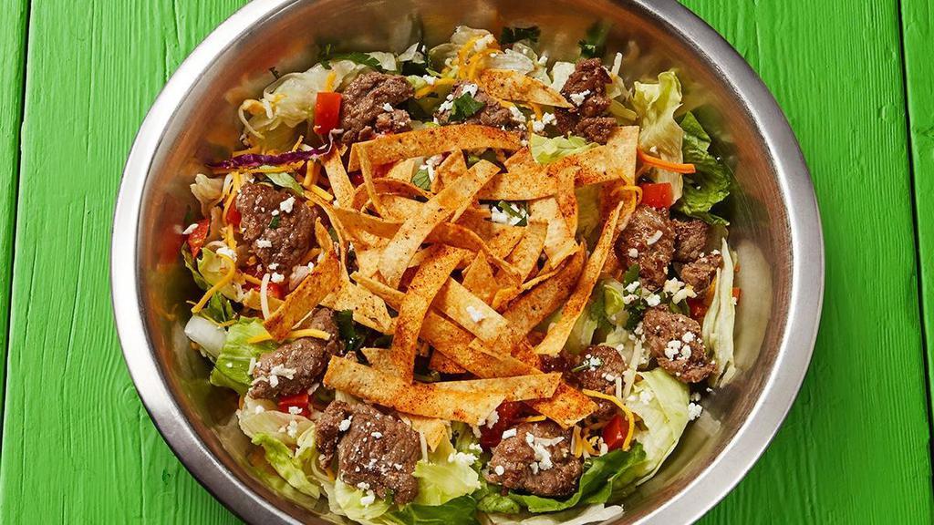 Fajita Beef Salad · Fajita beef served on a fresh lettuce blend topped with tomatoes, onions, shredded cheese, feta, cilantro, tortilla strips, and your choice of dressing.. {DF - remove shredded and feta cheese}