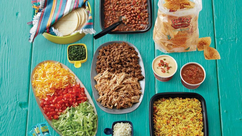 Large Taco Family Meal - Serves 6-8 · Includes choice of meat, two sides, chips, queso, salsa, and all the fixings - tortillas, lettuce, tomatoes, shredded cheese, cilantro, feta, garlic sauce.