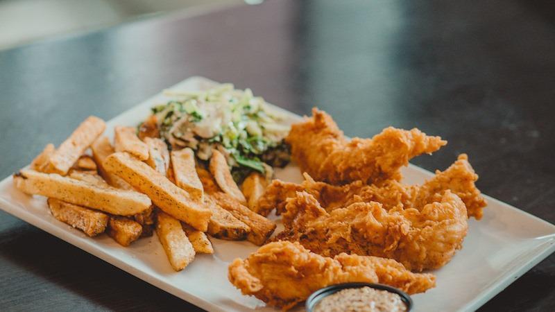 Hand Battered Chicken Tenders · Served with fries, slaw, and BBQ ranch.
