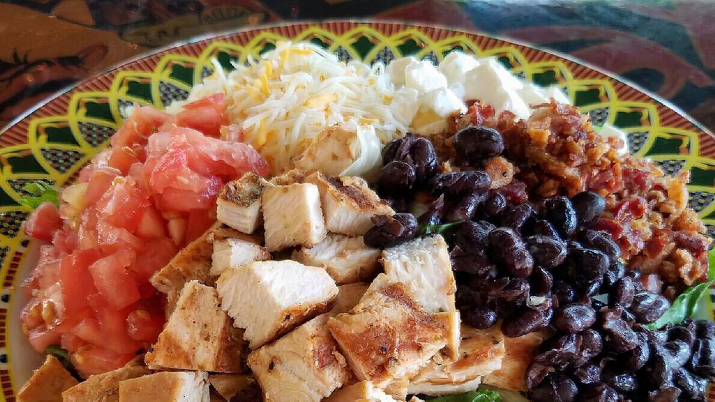 Mexican Cobb · Grilled chicken, cheddar and jack cheese, tomatoes, bacon, queso fresco, and black beans served on a bed of mixed greens with your choice of dressing.