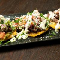 Loaded Tostones · 3 Tostones topped with churrasco, guacamole, pico de gallo and cilantro aioli