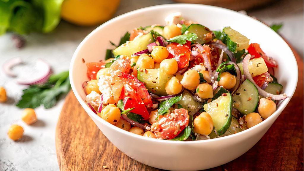 Mediterranean Chickpea Salad · Vegetarian. Seasoned chickpeas, tomato, bell peppers, green onions, kalamata olives, crumbled (vegan options without) cucumbers, and chopped zucchini, topped with homemade creamy dressing