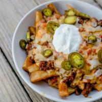 Seans Nachos · A heaping basket of tortilla chips or beer battered fries topped with beef, chili, rotel che...