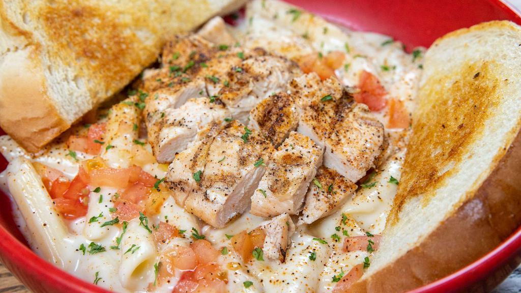 Rajun Cajun Pasta · Grilled cajun chicken breast served on a bed of penne pasta tossed in alfredo sauce, topped with cajun spices, diced tomatoes, and parsley.