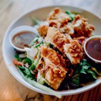 Crane Sisters Crispy Chicken Salad · Salad mix topped with crispy fried chicken tenders, diced tomatoes, red onions and almonds s...