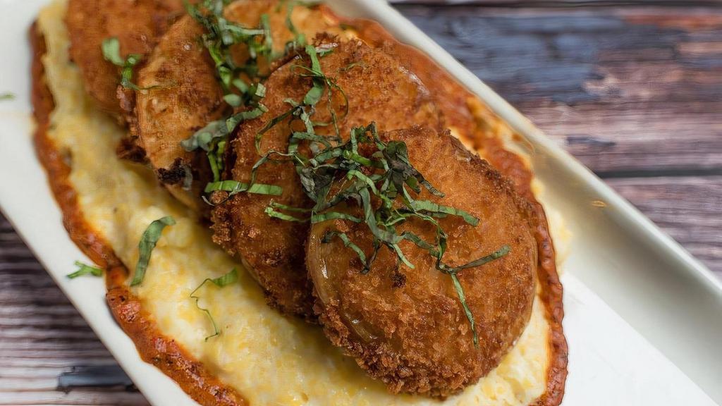 Famous Fried Green Tomatoes* · panko-crusted fried green tomatoes,  basil, roasted red pepper sauce, over heirloom grits with goat cheese