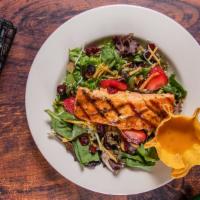 Grilled Salmon Salad · Salmon fillet on a bed of spring mix seasonal greens, and dried cranberries, toasted almonds...