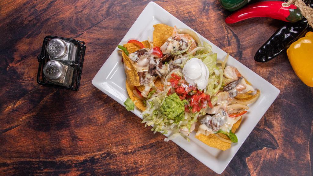 Texas Grilled Nachos · Grilled chicken, steak, and shrimp, onions, and peppers. Served on a bed of crispy tortilla chips topped with lettuce, melted cheese, crema, guacamole, and pico de gallo.