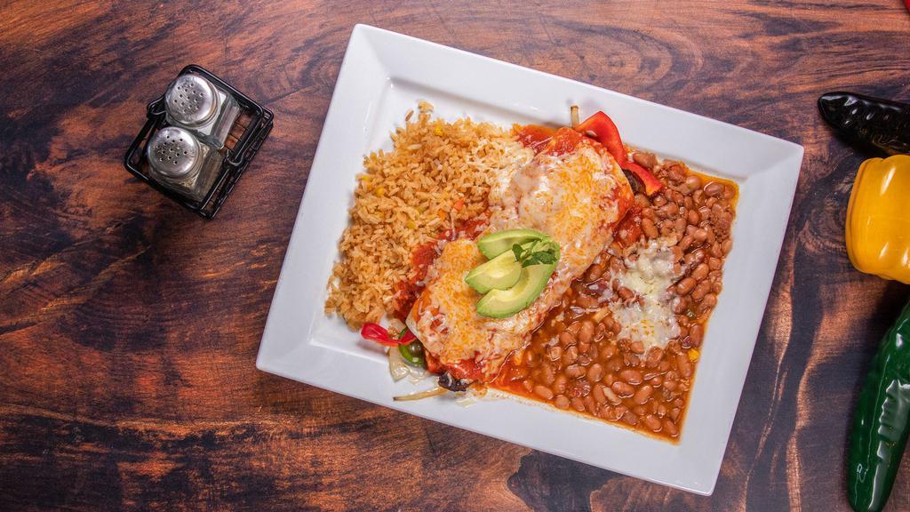 Burrito Ranchero · Our famous grilled chicken, grilled onions and peppers, topped with our zesty salsa ranchera, melted cheese and fresh avocado. Served with Mexican rice and Mexi-beans.