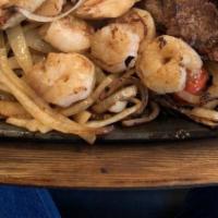 Texas Fajitas · Grilled skirt steak, chicken and shrimp sizzling hot, on a bed of bell peppers and onions. S...