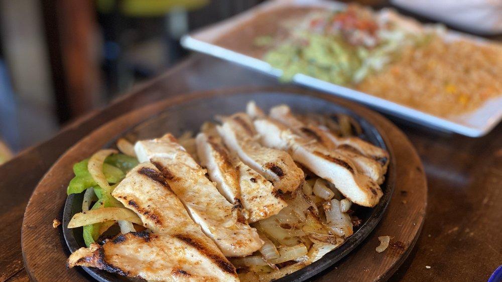 Chicken Fajitas · Fajitas grilled chicken (marinated in our own zama's recipe) sizzling hot, on a bed of bell peppers and onions. Served with Mexican rice, Mexi-beans, lettuce, pico de gallo, guacamole and crema. Choice of warm flour or corn tortillas.