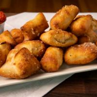 Garlic Bites · Puffs of our housemade dough, brushed with garlic butter and sprinkled with Parmesan cheese....