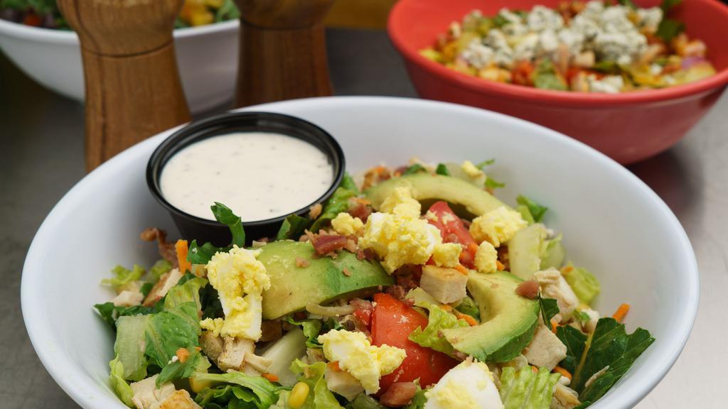 Southern Cobb Salad · Romaine lettuce, shredded carrots, boiled eggs, tomatoes, bleu cheese, corn, bacon, avocado, fried chicken and ranch dressing.