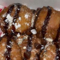 Fried Oreos  · Five fried Oreos layered with chocolate syrup and powdered sugar.