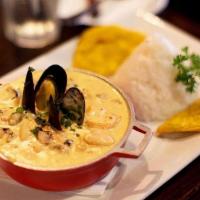 Cazuela Pacifico (Colombia) · Creamy seafood - coconut medley  served with White rice and patacon.