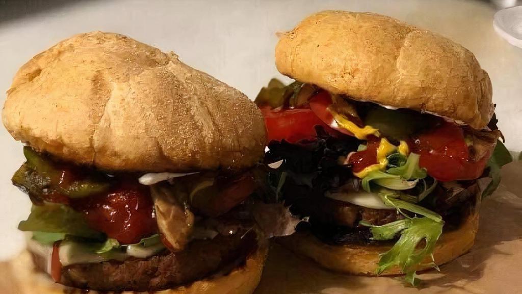 Veggie Vixen Burger · Two thinly sliced marinated eggplant pan seared with hummus topped with onions, bell peppers, lettuce, tomatoes, topped with fried onions on a potato or Arnold’s Wheat bun. Served with a side of your choice.