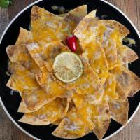 Super Nachos · Corn tortilla chips topped with refried beans, melted cheese, Mexican crema, guacamole, and ...