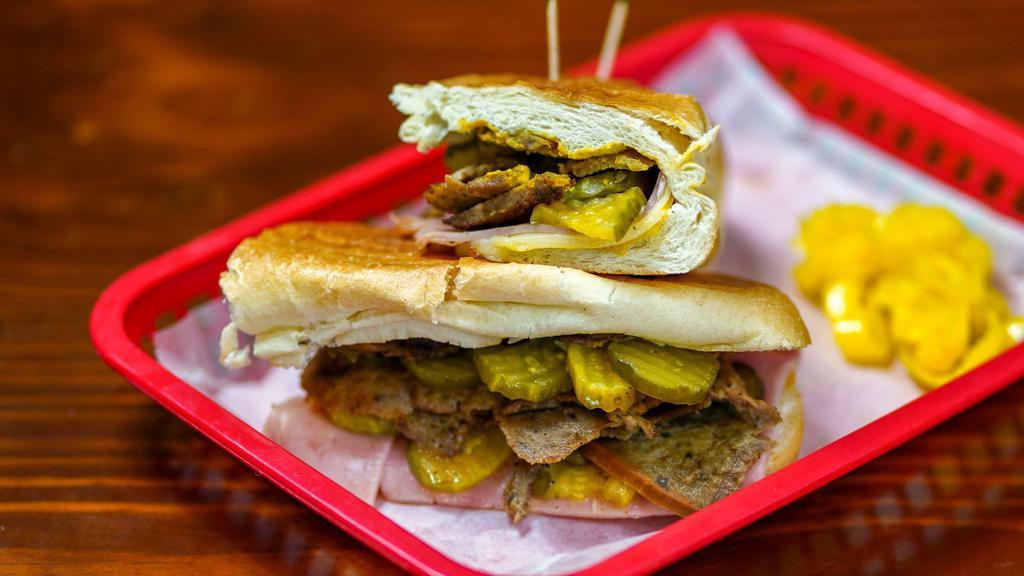 Greek-Cubano · Lamb & Beef Gyro Meat  with ham, Swiss cheese, pickles, and mustard  
pressed together on  a Cuban Roll