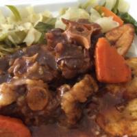 Curried Goat (Large) · Served with a choice of rice and peas white or yellow rice steamed vegetables and tossed sal...
