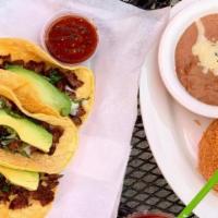 Tacos Al Carbon · Three soft tacos filled with onions, cilantro, avocado. Served with spicy tomatillo sauce, r...