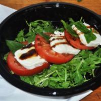 Caprese Salad · Spring mix, buffalo mozzarella, Roma tomatoes and kalamata olives. Served with a side of Rus...