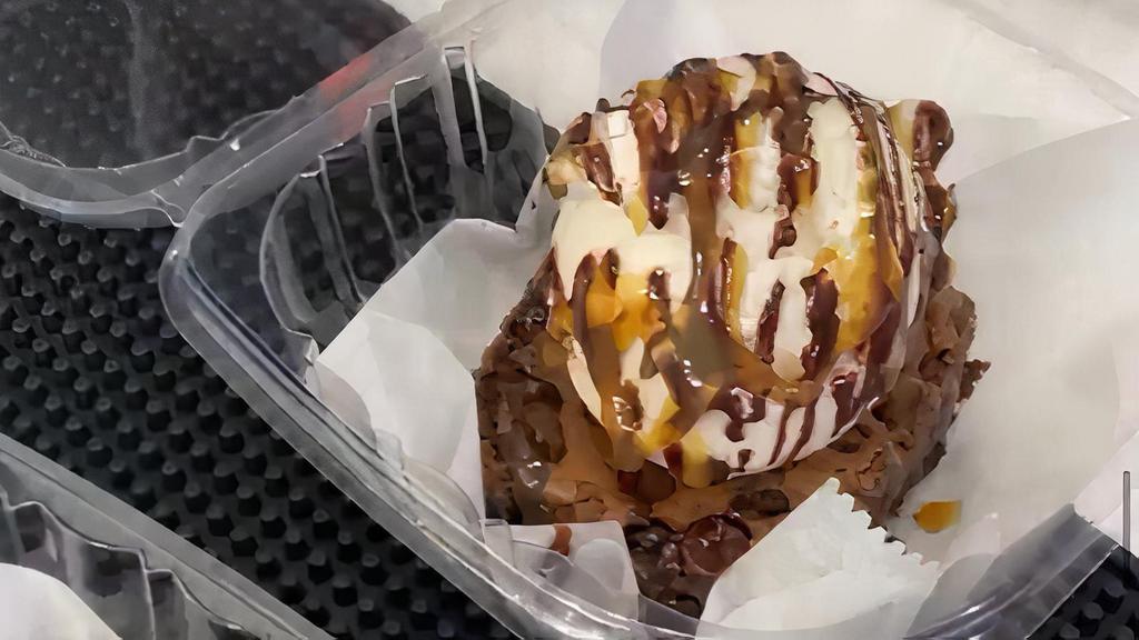 Brownie Overload · Chocolate brownie topped with a scoop of ice cream, chocolate syrup, caramel, and a side of whip cream.