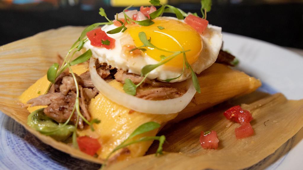 Tamal Completo · Park corn tamal, extra pork meat and a fried egg in top pico de gallo and avocado.