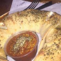 Stromboli · Pizza dough rolled into a crescent moon shape and filled with mozzarella cheese, pepperoni, ...