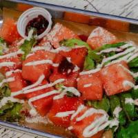 Sandia Salad · Chunks of sweet watermelon, jicama, Mexican cream, hibiscus, honey limon pepper, and coija c...