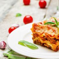 Lasagna · Three layers of tender pasta with creamy ricotta, ground beef, romano cheese, homemade tomat...