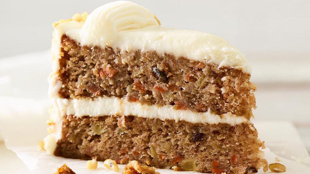 Carrot Cake Slice · Two-layer cake with shredded carrots, pineapple, sweetened coconut and pecan pieces, covered in cream cheese frosting and garnished with walnuts.