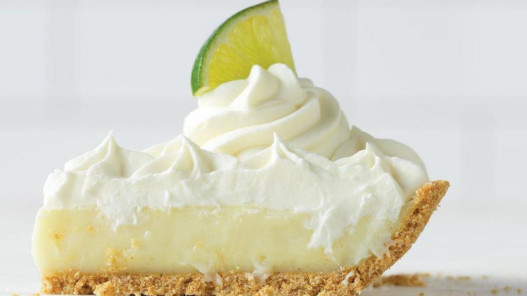 Key Lime Pie Slice · Cool and refreshing, this is a summer seasonal favorite. Tangy Key limes are blended with sweetened condensed milk and eggs, baked inside a graham cracker crust, then topped with real whipped cream and a fresh slice of lime for the perfect balance of tart and sweet.