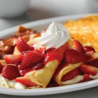 Strawberry Crêpes Combo · Two strawberries and cream crêpes, served with hash browns and two bacon strips or two sausa...