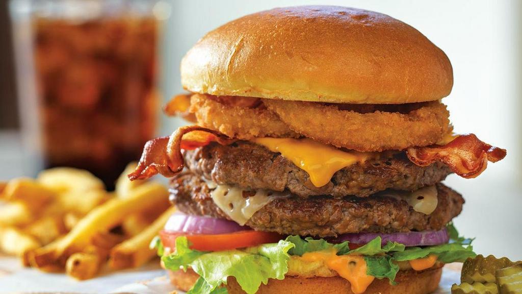 All-World Double Cheeseburger®* · Layers of American and Swiss cheeses on two juicy burger patties topped with two cherrywood-smoked bacon strips, onion rings and Thousand Island dressing.