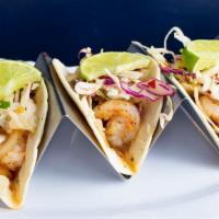 Shrimp Tacos · Served on soft tortillas with onions and cilantro-lime slaw