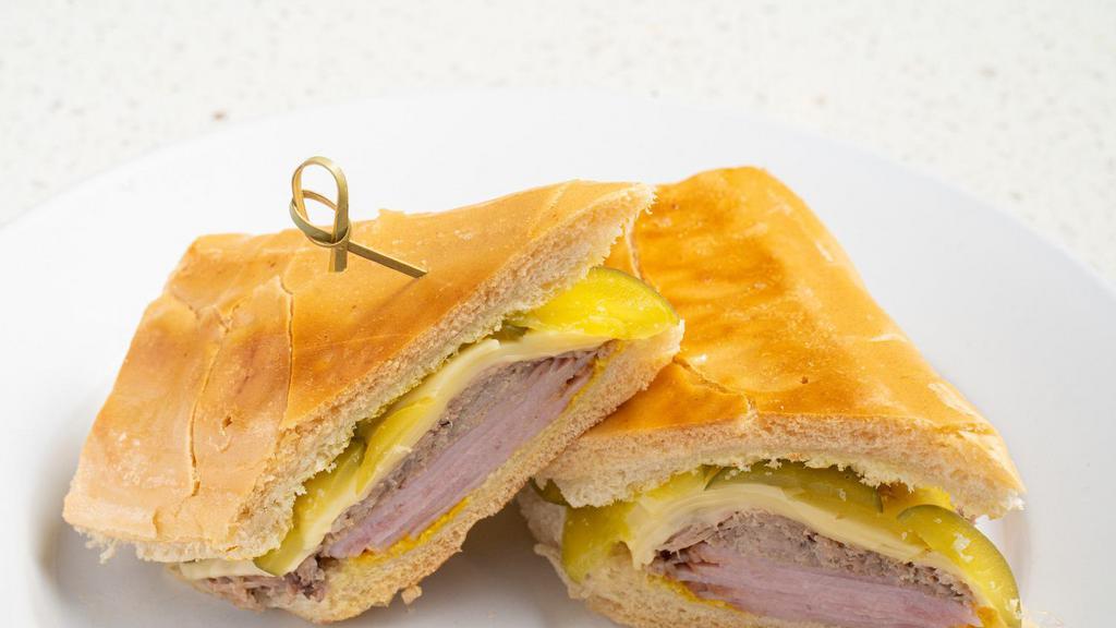 Cuban Sandwich / Cubano · Roasted Pork, Ham, Swiss Cheese, Pickles & Mustard on toasted Cuban Bread