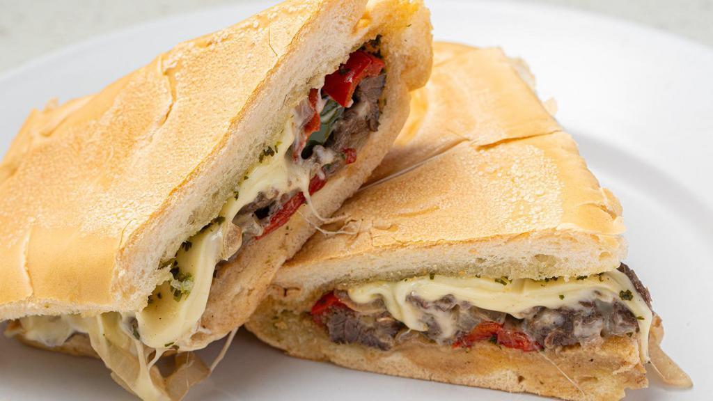 Cuban Philly Sandwich · Thin slices of Skirt Steak, grilled onions & peppers, melted Swiss cheese topped with Chimichurri Sauce on toasted Cuban bread