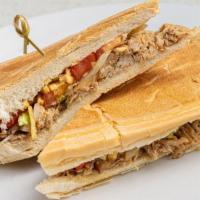 Pan Con Lechon · Roasted pork topped with grilled onions, lettuce, tomatoes & potato sticks on toasted Cuban ...