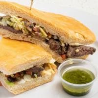 Churrasco Sandwich · Grilled skirt steak topped with grilled onions, lettuce, black bean pico de gallo & potato s...