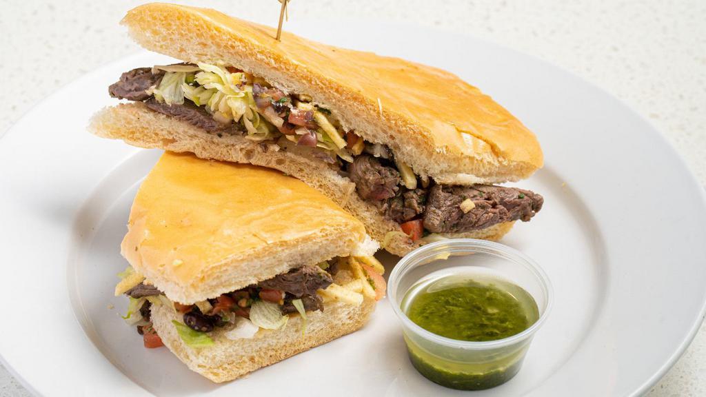 Churrasco Sandwich · Grilled skirt steak topped with grilled onions, lettuce, black bean pico de gallo & potato stickes on toasted Cuban bread with side of Chimichurri sauce.