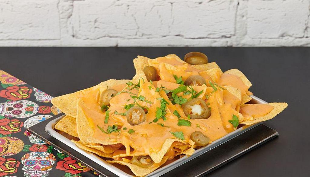 Small Nachos · Crispy corn tortilla chips with shredded cheese, queso, pickled jalapeno, cilantro, and your choice of sauce.