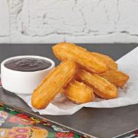 Churros · Churros with a side of chocolate sauce.