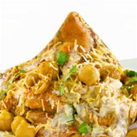 Samosa Chat · Crushed samosa with chickpeas and finished with yogurt, chutney, and spices.
